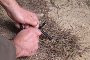 Hands using a Fire-starter tool. Survival skills and techniques
