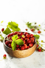 Wild strawberry in wooden bowl