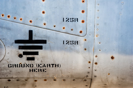 Simbolo electrico de tierra  en fuselaje de avion militar