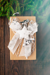Christmas gift in a beautiful and elegant box with fir branches and cones on the rustic wooden table in vintage style, toned. Holiday concept
