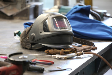Welding helmet in factory - obrazy, fototapety, plakaty