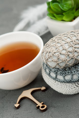 Cup of black tea and crocheted pebbles