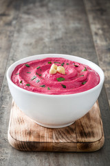 Beet hummus and ingredients on wooden table

