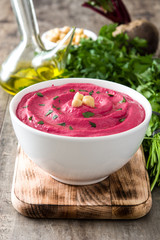 Beet hummus and ingredients on wooden table

