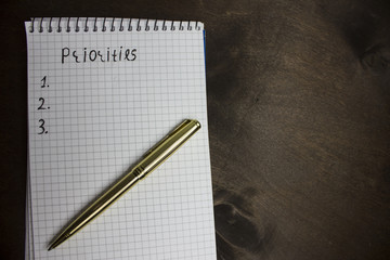 close up of blank list of priorities and metal pen