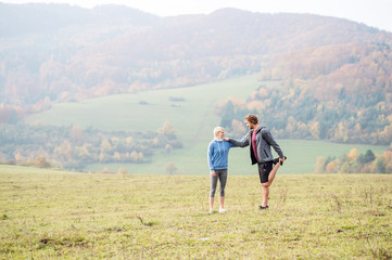 Fototapeta na wymiar Two young beautiful runners in autumn nature, stretching legs
