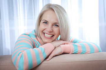 Attractive middle aged woman relaxing at home. The beautiful face close up.