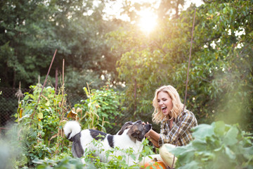 Beautiful blond woman with dogs in green garden