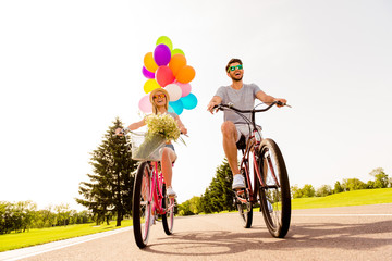 Positive happy couple in love having fun and riding bicycles