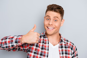 Portrait of young toothy man showing 
