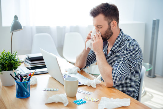 businessman having cold in the head and sitting at workplace .