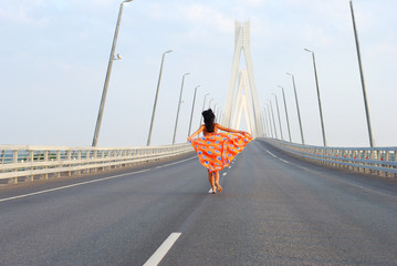 Young adult walking over  bridge