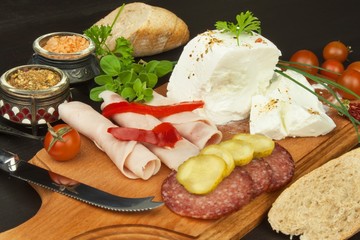 Goat cheese with vegetables and ham. Healthy diet meals for children. Goats cheese on a cutting board.
