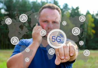 Business, technology, Internet and virtual reality concept - businessman 5g presses on the touch screen with the world map .Businessman talking on the phone and touching the wireless icon.