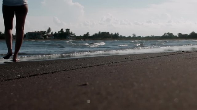 WOMAN WALKING ON THE BEACH