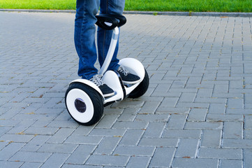 man rides on gyroscooter on the pavement in park.