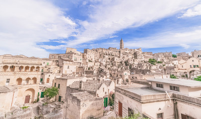 Obraz premium panoramic view of typical stones (Sassi di Matera) and church of Matera under blue sky