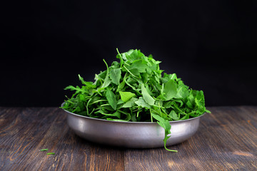 Obraz na płótnie Canvas Concept of healthy eating, vegetarian diet. Green rock salad in aluminium bowl. Selective focus. Special light.