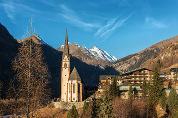 Fototapeta na wymiar Old alpine village, surrounded by Alps Mountains with blue sky, Heiligenblut am Grossglockner, Austria, Europe
