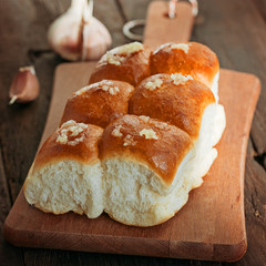 Buns with garlic on a wooden background