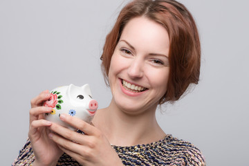 Junge hübsche Frau mit Sparschwein