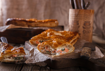 Cake of puff pastry with savory stuffing ,with salmon and spinach.selective focus.