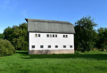Fototapeta na wymiar White barn on a sunny summer day
