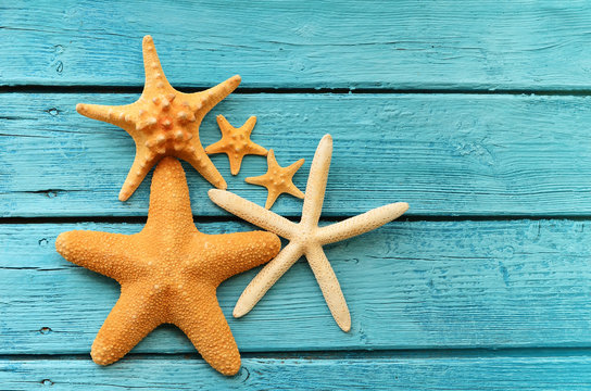  Starfish on blue wooden background.