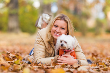Smiling young woman hugging her dog out in the park