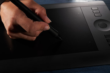 hand draws a black professional graphics tablet