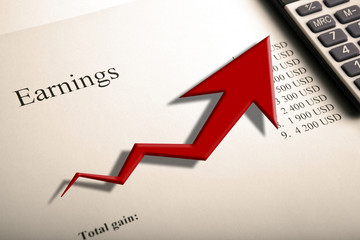 table with earnings with digits, calculator and diagram