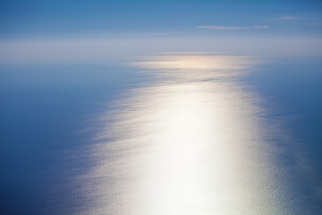 Obraz premium Water sea surface on the sunset, aerial view from the plane porthole