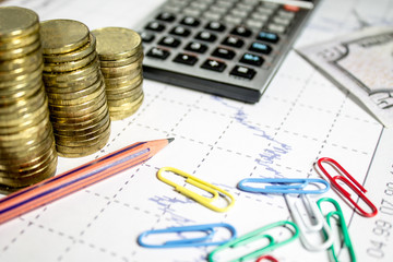 finance business calculation with chart,calculator,color clips,pencil and coins