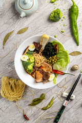Soup with seafood, noodles and vegetables in a white plate
