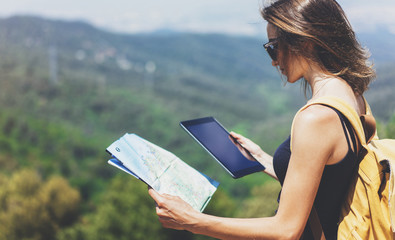 Hipster young girl with backpack enjoying panoramic mountain sea, using map and looking at horizon. Tourist traveler texting on tablet computer on background landscape Barcelona view mockup
