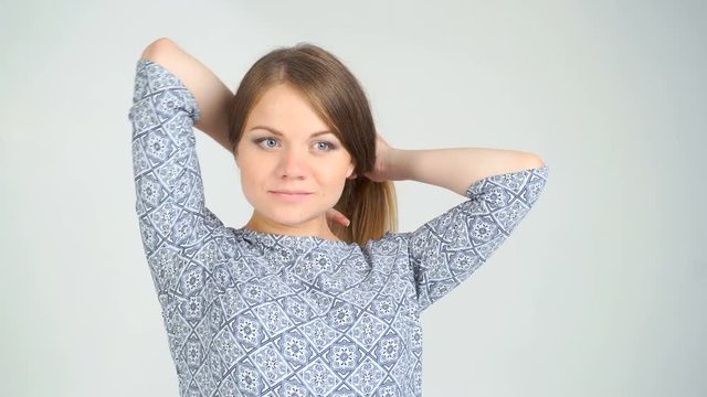 pregnant woman braids the hair and pats belly