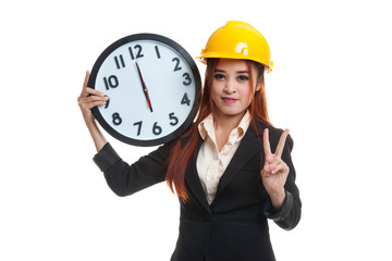 Asian engineer woman show victory sign with a clock.