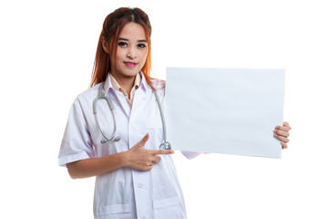 Young Asian female doctor point to a blank sign.