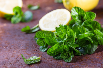 Fresh mint and lemon slices on rustic background