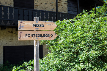 wooden direction signs for Pezzo and Ponte di Legno, Italy