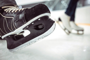 Man's hockey and women' figure skates on ice background. Closeup of blades. © Northern life
