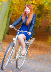 Plakat Young lady is smiling and riding the bike.