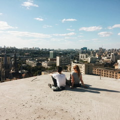 Boy and girl on the roof, city view.