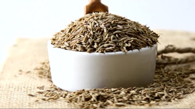 Cumin seeds pouring rotating in a bowl