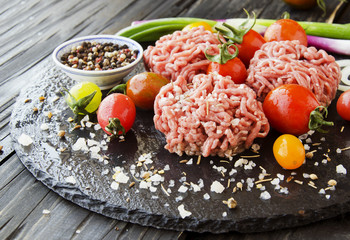raw minced meat, vegetables with salt and spices, selective focus