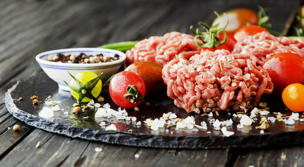 raw minced meat, vegetables with salt and spices, selective focus