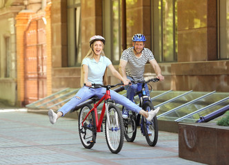 Happy couple riding bicycles on the street