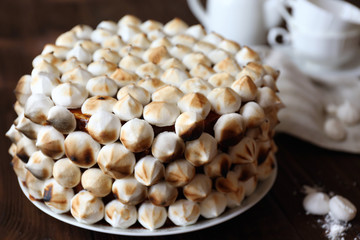 Tasty cake decorated with marshmallow on wooden table