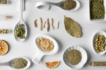 Flat lay of assorted herbs and spices on white background