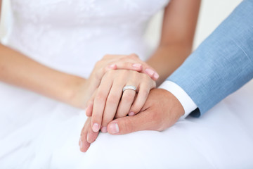 Bride and groom holding hands together indoor